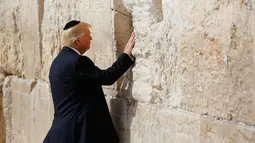 Presiden AS Donald Trump menyentuh Tembok Ratapan saat mengunjungi tempat suci milik kaum Yahudi itu di Yerusalem, Senin (22/5). Ini adalah pertama kalinya Presiden Amerika Serikat mengunjungi dan berdoa di lokasi tersebut. (AP Photo/Evan Vucci)