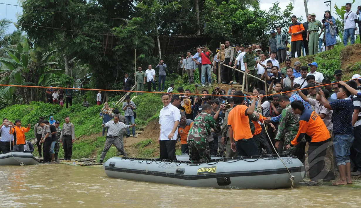 Menteri Pendidikan dan Kebudayaan, Anies Baswedan menaiki perahu karet saat meninjau lokasi jembatan runtuh di Lebak, Banten, Senin (16/3/2015). (Liputan6.com/Herman Zakharia)