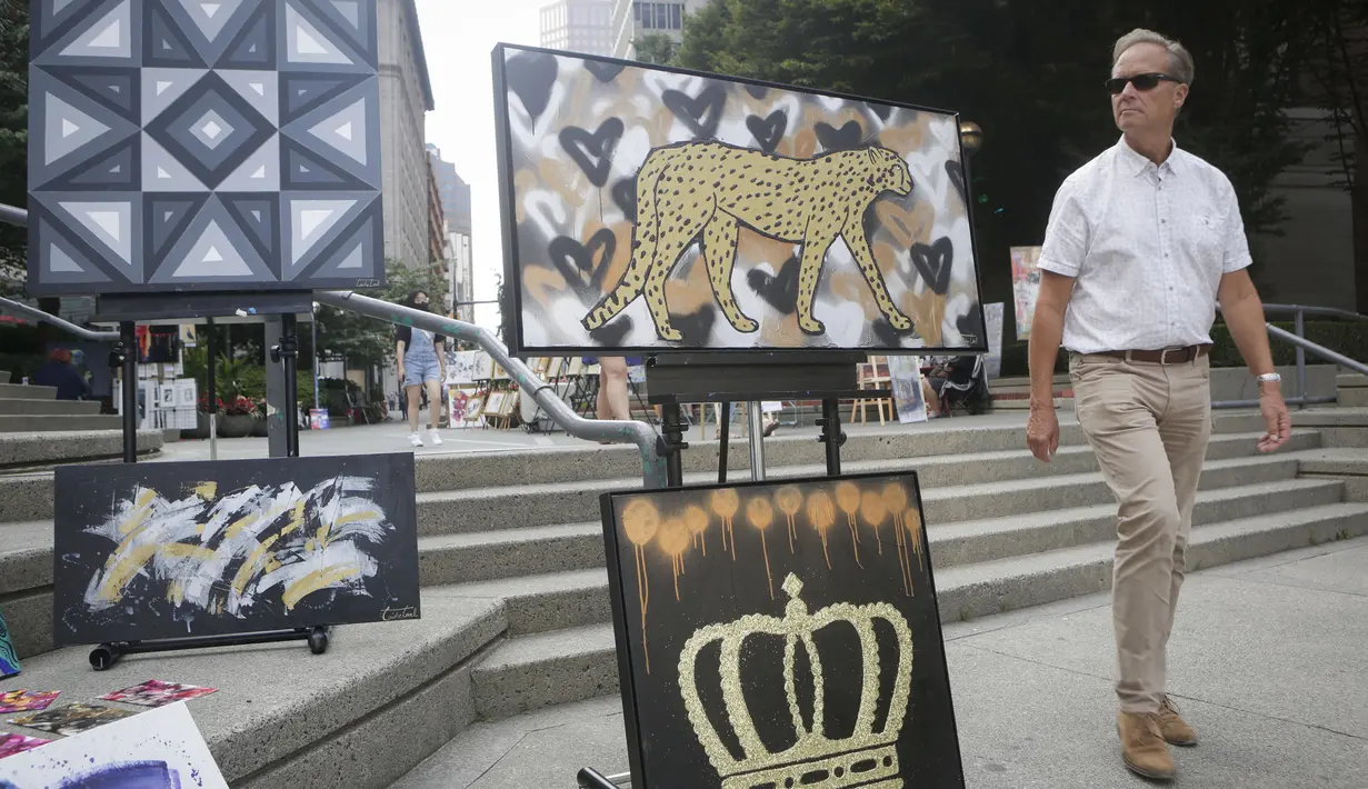 Seorang pria mengamati karya seni yang dipajang di area terbuka dalam pameran Art Downtown, Vancouver, British Columbia, Kanada, 4 September 2020. Art Downtown merupakan proyek yang memungkinkan seniman dan publik saling terhubung dan menginspirasi serta berbagi kreativitas. (Xinhua/Liang Sen)