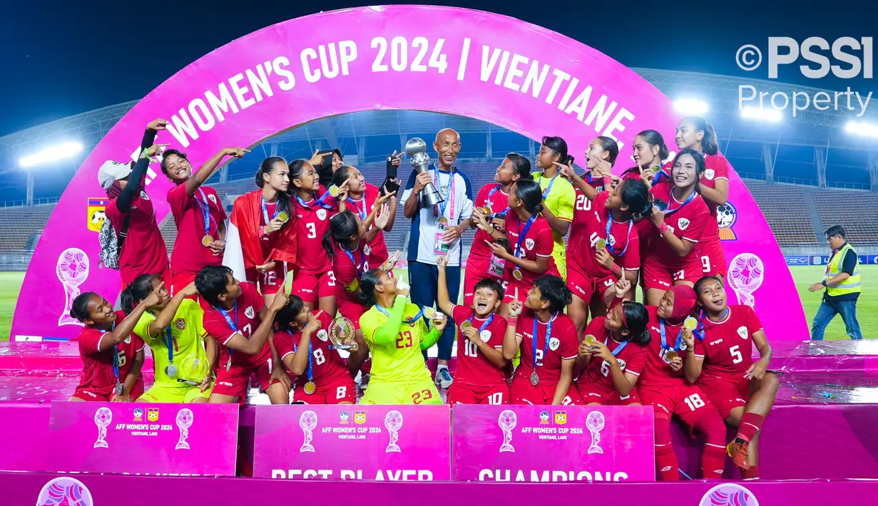 Pelatih Timnas Indonesia Putri, Satoru Mochizuki (tengah) mengangkat trofi bersama para pemainnya saat merayakan gelar juara Piala AFF Wanita 2024 setelah mengalahkan Kamboja 3-1 pada laga final yang berlangsung di New Laos National Stadium, Vientiane, Kamis (05/12/2024) malam WIB. (Dok. PSSI)