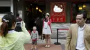 Pengunjung saat difoto didepan restoran yang menjajikan makanan dalam bentuk Hello Kitty di Hong Kong, China, Kamis (21/5/2015). Rencananya, restoran ini akan resmi dibuka pada 1 Juni. (REUTERS/Bobby Yip)