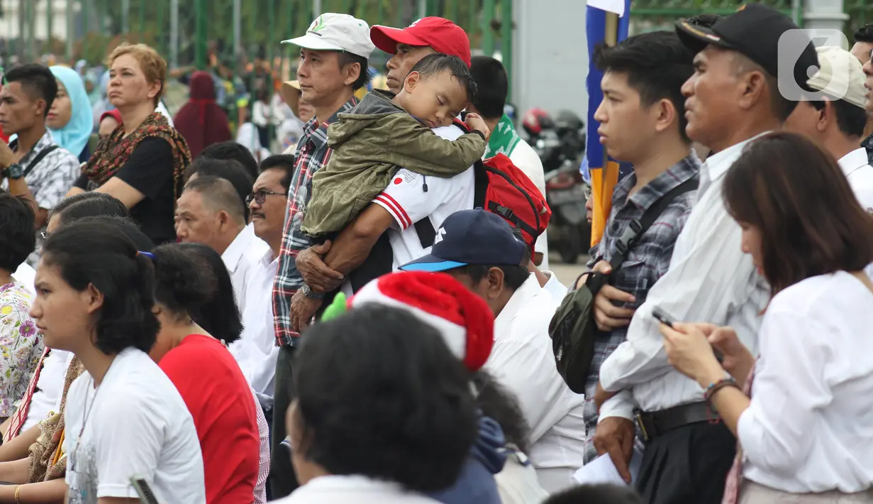 Jemaat dari Gereja Kristen Indonesia (GKI) Yasmin Bogor dan HKBP Filadelfia Bekasi melaksanakan misa Natal di Simpang Barat Laut Monas atau depan Istana Negara, Jakarta, Rabu (25/12/2019). Ini adalah misa natal kedelapan yang digelar jemaat dua gereja tersebut. (Liputan6.com/Helmi Fithriansyah)