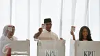Cagub DKI Jakarta, Anies Baswedan bersama istri dan anaknya menunjukan kertas suara saat akan menggunakan hak pilihnya di TPS 28 Cilandak, Jakarta Selatan, Rabu (19/4). (Liputan6.com/Yoppy Renato)