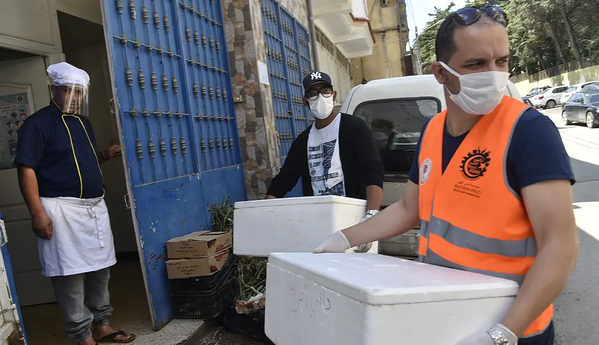 Relawan dari asosiasi Nass el-Khir mendistribusikan makanan kepada mereka yang membutuhkan selama bulan suci Ramadan di Aljir, Aljazair, Senin (18/5/2020). (RYAD KRAMDI/AFP)