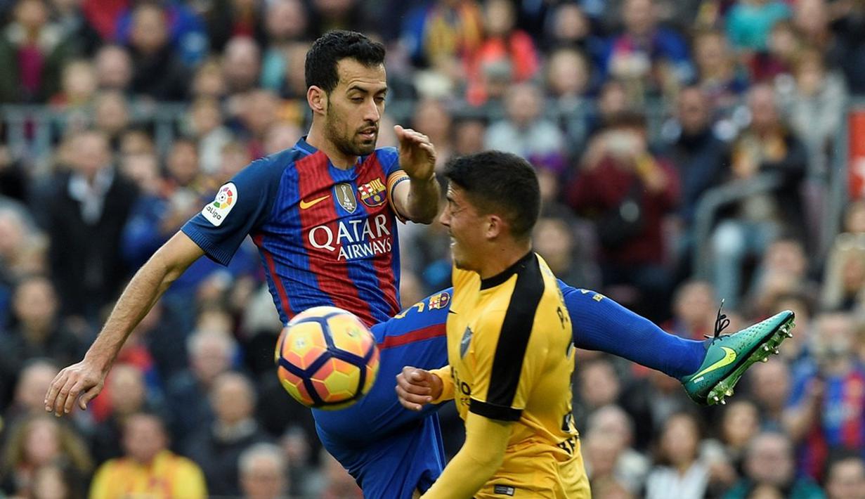 Gelandang Barcelona, Sergio Busquets, berebut bola dengan gelandang Malaga, Pablo Fornals, dalam lanjutan La Liga di Camp Nou, Barcelona, Sabtu (19/11/2016). (AFP/Lluis Gene)