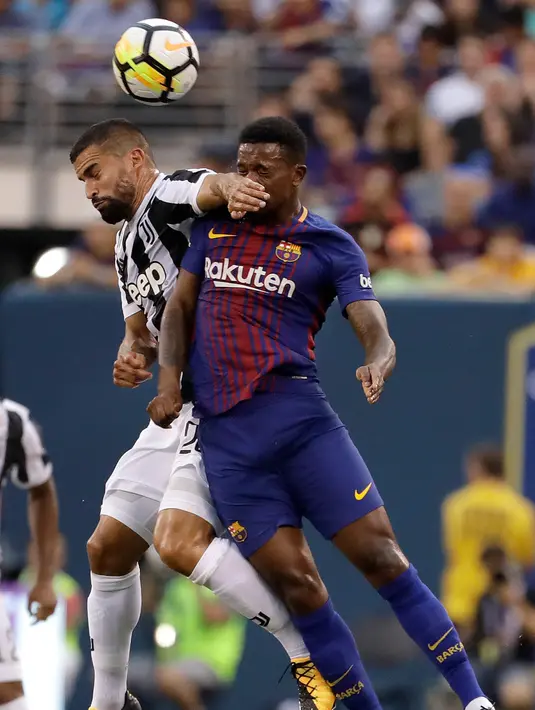 Pemain Juventus Tomas Rincon berebut bola udara dengan pemain Barcelona, Nelsinho saat bertanding pada ICC 2017 di Stadion MetLife di East Rutherford, N.J. (22/7). Barcelona menang atas Juventus dengan skor 2-1. (AP Photo / Julio Cortez)