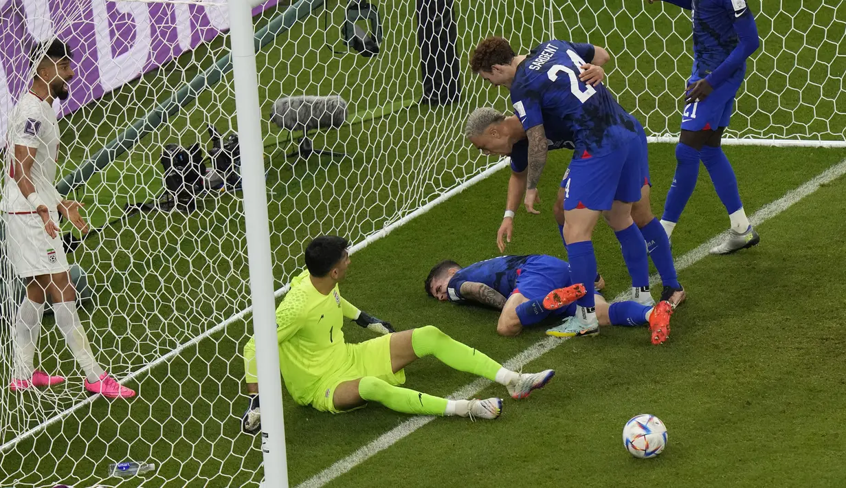 Gelandang Amerika Serikat Christian Pulisic cedera d lapangan setelah bertabrakan dengan kiper Iran Alireza Beiranvand pada laga pamungkas Grup B Piala Dunia 2022 di Stadion Al Thumama, Rabu (30/11/2022) dini hari WIB. Pulisic cedera usai mencetak gol pada menit ke-38 dan kemudian dilarikan ke rumah sakit. (AP Photo/Luca Bruno)
