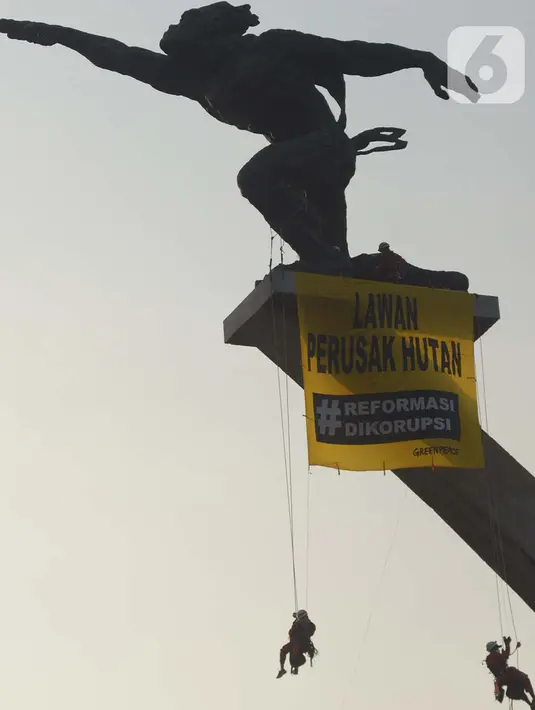 Sejumlah orang membentangkan spanduk di Patung Dirgantara Pancoran, Jakarta, Rabu (23/10/2019). Aksi tersebut menyerukan pesan kepada Presiden Joko Widodo atau Jokowi untuk meninggalkan energi kotor seperti batu bara. (merdeka.com/Imam Buhori)