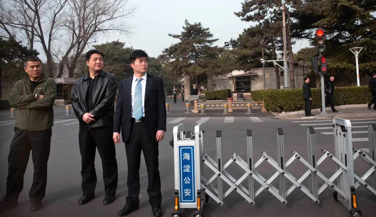 Petugas keamanan berpakaian preman memblokir jalan di depan Wisma Negara Diaoyutai, Beijing, China, Selasa (27/3). Pengamanan tidak biasa ini menimbulkan spekulasi bahwa Pemimpin Korea Utara Kim Jong-un ada di Beijing. (AP Photo/Mark Schiefelbein)
