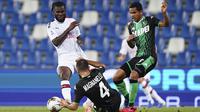 Pemain AC Milan Franck Kessie (kiri) dan pemain Sassuolo Rogerio (kanan) berebut bola pada pertandingan Serie A Italia di Stadion Mapei, Reggio Emilia, Italia, Selasa (21/7/2020). AC Milan menang 2-1 sekaligus menggeser posisi AS Roma dari posisi lima klasemen. (Spada/LaPresse via AP)