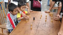 Anak-anak mengikuti permainan tradisional pada Pekan Kebudayaan Nasional di Istora Senayan, Jakarta, Sabtu (12/10/2019). Perhelatan itu dimeriahkan kompetisi olahraga tradisional berupa permainan rakyat seperti egrang, lari balok, terompah panjang, dan hadang.. (Liputan6.com/Angga Yuniar)