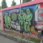 Pemotor melintasi mural bertema covid-19 di Tanah Tinggi, Tangerang, Sabtu (29/1/2022). Kasus Covid-19 varian Omicron di Indonesia terus bertambah dan wilayah penyebarannya semakin meluas. Diperkirakan, kasus omicron sudah mendominasi penularan virus corona di Jawa Bali. (Liputan6.com/Angga Yuniar)