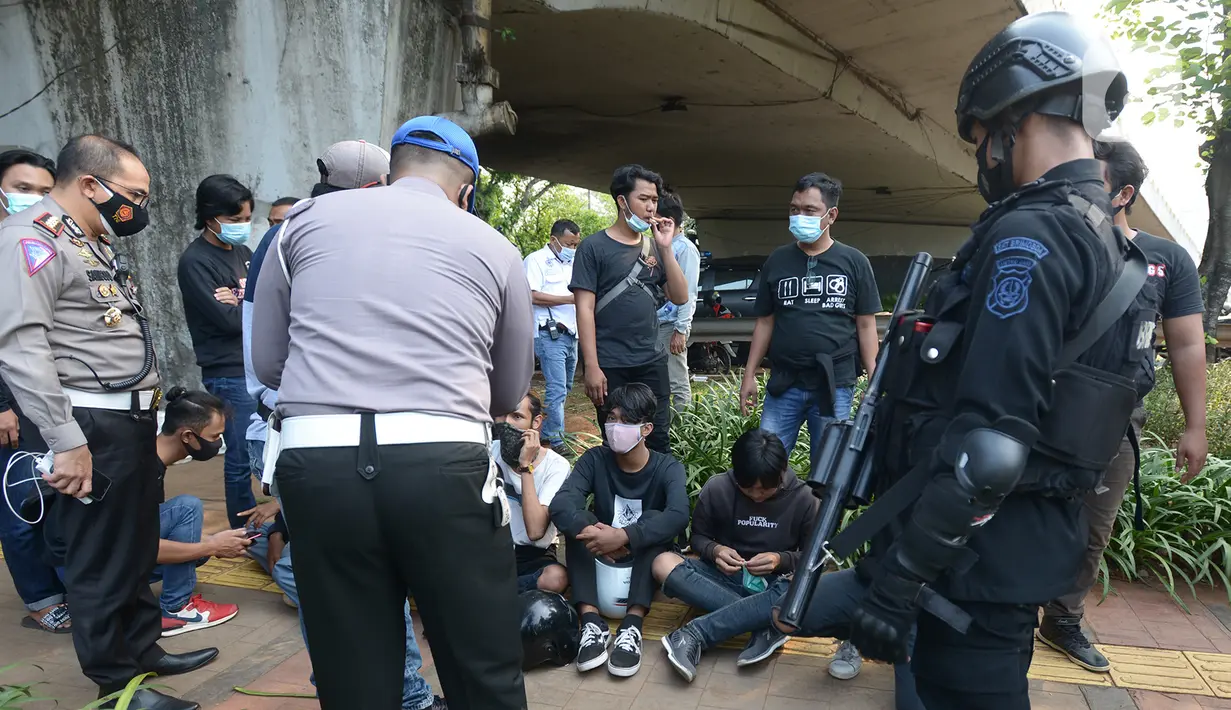 Polisi merazia pelajar yang sedang berkumpul di sekitar Gedung DPR/MPR, Jalan Gatot Subroto, Jakarta, Rabu (7/10/2020). Sejumlah akses jalan menuju lokasi dijaga menyusul adanya aksi demonstrasi kelompok buruh yang menolak UU Omnibus Law Cipta Kerja. (merdeka.com/Imam Buhori)