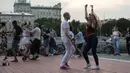 Warga berdansa pada hari pertama berakhirnya lockdown di tanggul Sungai Moskow, Moskow, Rusia, Selasa (9/6/2020). Warga Moskow bebas beraktivitas setelah dua bulan menjalani lockdown akibat pandemi virus corona COVID-19. (AP Photo/Pavel Golovkin)