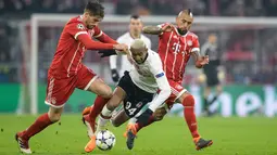 Pemain Besiktas, Talisca berebut bola dengan pemain Bayern Munchen, Javi Martinez dan Arturo Vidal pada pertandingan pertama babak 16 besar Liga Champions di Allianz Arena, Selasa (20/2). Bayern menang telak dengan skor 5-0. (Matthias Balk/dpa via AP)