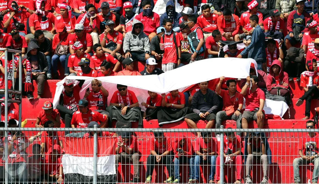 Suporter menggunakan spanduk untuk menghindari panas matahari di Stadion I Wayan Dipta, Gianyar, Bali, Minggu (30/8). Jelang pembukaan turnamen Piala Presiden 2015, ribuan suporter menyerbu stadion Dipta, Gianyar, Bali. (Liputan6.com/Helmi Fithriansyah) 