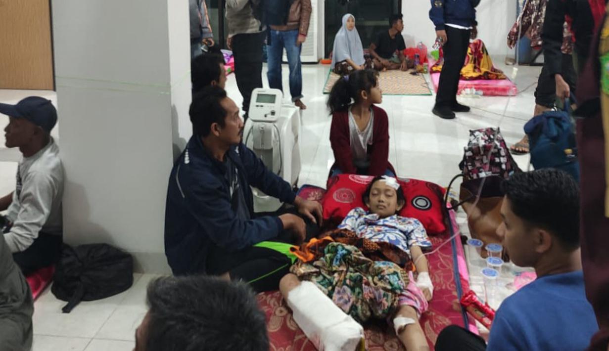 Foto selebaran yang diambil dan dirilis pada 7 Maret 2023 oleh kantor Kementerian Komunikasi dan Informatika Natuna ini menunjukkan seorang korban luka dari sebuah desa yang terkena tanah longsor di di Natuna, Kepulauan Riau (Kepri), dirawat di tempat yang aman sebelum dievakuasi menuju rumah sakit. (HO / Natuna ministry of communication / AFP)