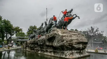 Aktivitas pembersihan dan perawatan patung kuda Arjuna Wijaya di Jalan Medan Merdeka, Jakarta, Rabu (27/1/2021). Patung yang dibangun sejak 1987 karya pematung Nyoman Nuarta tersebut dibersihkan dan ditata kembali untuk memperindah kota. (Liputan6.com/Faizal Fanani)