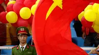 Seorang polisi berjaga di antara kibaran bendera Vietnam saat laga semifinal Piala AFF 2016 melawan Timnas Indonesia di Stadion My Dinh, Hanoi, Kamis (7/12/2016). (Bola.com/Peksi Cahyo) 