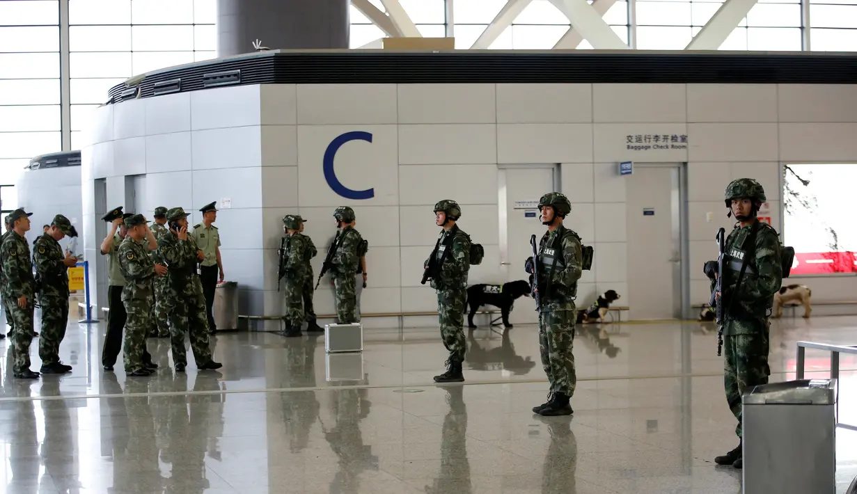 Polisi militer dan anjing pelacak berada di dekat lokasi ledakan di Bandara Internasional Pudong, Shanghai, China, Minggu (12/6). Polisi berhasil mengendalikan lokasi dan tak ada jadwal penerbangan yang terganggu akibat peristiwa itu. (REUTERS/Aly Song)