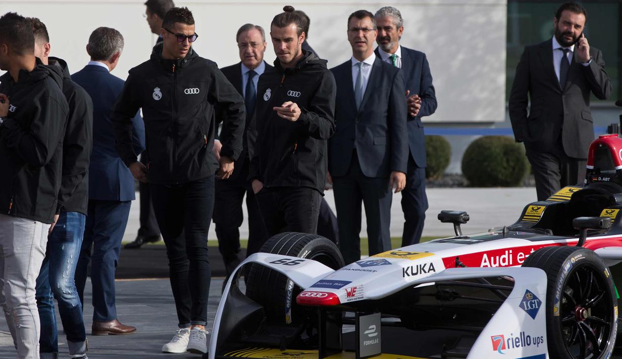 Penyerang Real Madrid Cristiano Ronaldo dan Gareth Bale melihat mobil balap Formula E yang dipamerkan saat sebuah acara promosi di Madrid, Spanyol, (23/11). (AP Photo / Paul White)