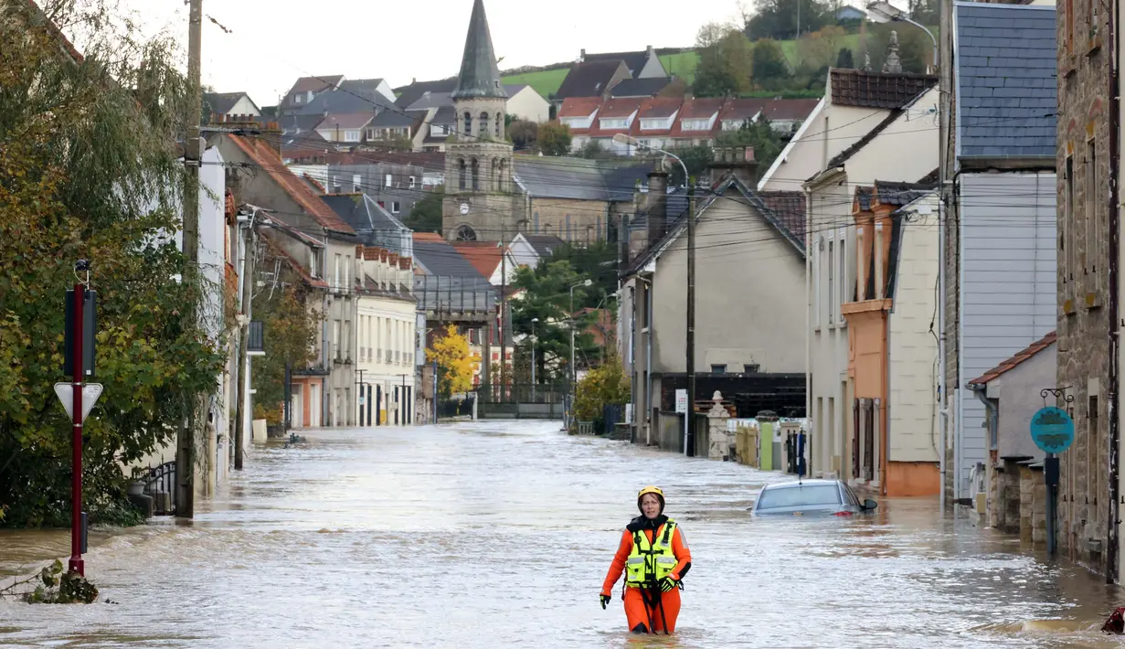 Seorang petugas pemadam kebakaran Prancis berjalan di jalanan yang tergenang banjir di Isques, Prancis Utara pada tanggal 7 November 2023. (DENIS CHARLET/AFP)