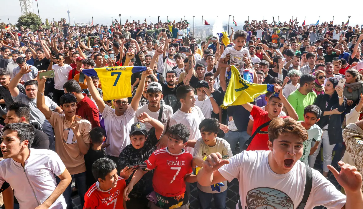 Sejumlah masyarakat Tehran membawa jersey Cristiano Ronaldo saat menyambut kedatangan Al-Nassr menjelang laga Liga Champions Asia 2023 melawan Persepolis FC, Selasa (19/09/2023). (AFP/Payam Parsae)