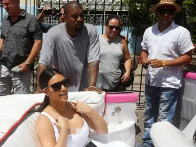 Musisi Kanye West menemani istrinya Kim Kardashian yang berada di mobil kuno setelah meninggalkan sebuah restoran di Havana, Cuba, 5 Mei 2016. Kim bersama seluruh anggota keluarganya ke Kuba untuk syuting serial reality show miliknya. (REUTERS / Stringer)