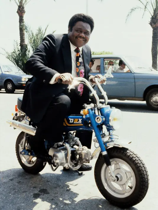 Foto yang diambil 18 Juli 1980 menunjukkan musisi Fats Domino menaiki motor Dax Honda di Nice, Prancis. Pemilik nama asli Antoine Domino, Jr tersebut menghabiskan lebih dari separuh hidupnya di dunia musik. (AFP Photo/Ralph Gatti)