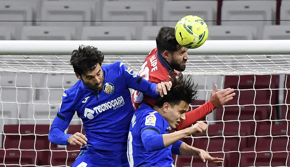 Bek Atletico Madrid, Felipe, duel udara dengan pemain Getafe, Enes Unal dan Xabier Etxeita, pada laga Liga Spanyol di Stadion Wanda Metropolitano, Rabu (30/12/2020). Atletico Madrid menang dengan skor 1-0. (AFP/Oscar Del Pozo)