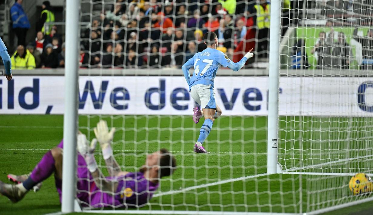 Pemain Manchester City, Phil Foden, mencetak gol ke gawang Brentford pada laga Liga Inggris di Stadion Gtech Community, Selasa (6/2/2024). Tambahan tiga poin ini mendorong posisi Man City ke peringkat dua klasemen Liga Inggris sementara dengan 49 poin dari 22 pertandingan. (AFP/Ben Stansall)