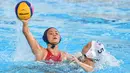 Pemain Indonesia, Ariel Dyah Cininta Siwabessy (kiri) menembakkan bola ke gawang Jepang dalam babak penyisihan polo air putri Grup A Asian Games 2018 di Jakarta, Kamis (16/8). Indonesia kalah 4-15. (PETER PARKS/AFP)