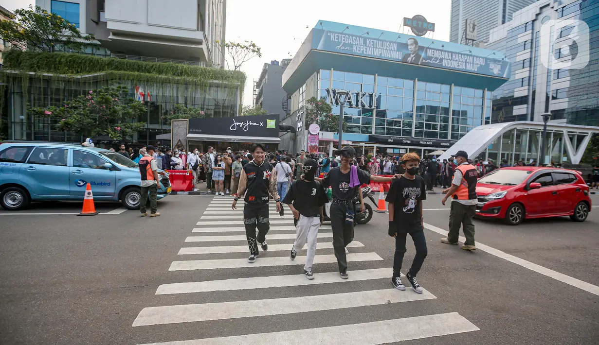 Personel gabungan dari unsur polisi hingga Satpol PP mengatur lalu lintas di kawasan zebra cross Dukuh Atas, Jakarta, Rabu (27/7/2022). Mereka dikerahkan untuk memantau kegiatan peragaan busana Citayam Fashion Week (CFW) guna meminimalisir terjadinya kriminalitas, kemacetan, hingga parkir liar. (Liputan6.com/Faizal Fanani)