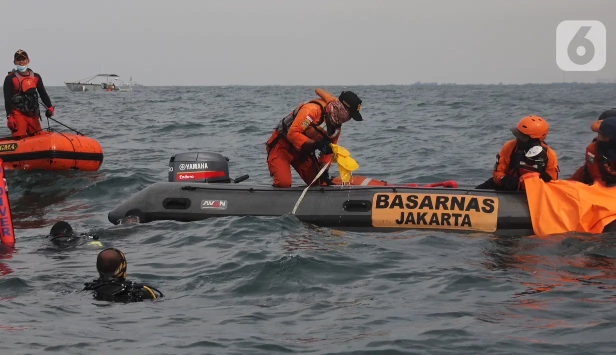 Anggota Tim SAR Gabungan mengevakuasi serpihan pesawat  Sriwijaya Air SJ 182 di perairan Kepulauan Seribu, Jakarta, Senin  (11/1/2021). Pesawat Sriwijaya Air SJ 182 dengan rute Jakarta-Pontianak mengalami hilang kontak setelah lepas landas dari Bandara Soekarno-Hatta. (merdeka.com/Arie Basuki)