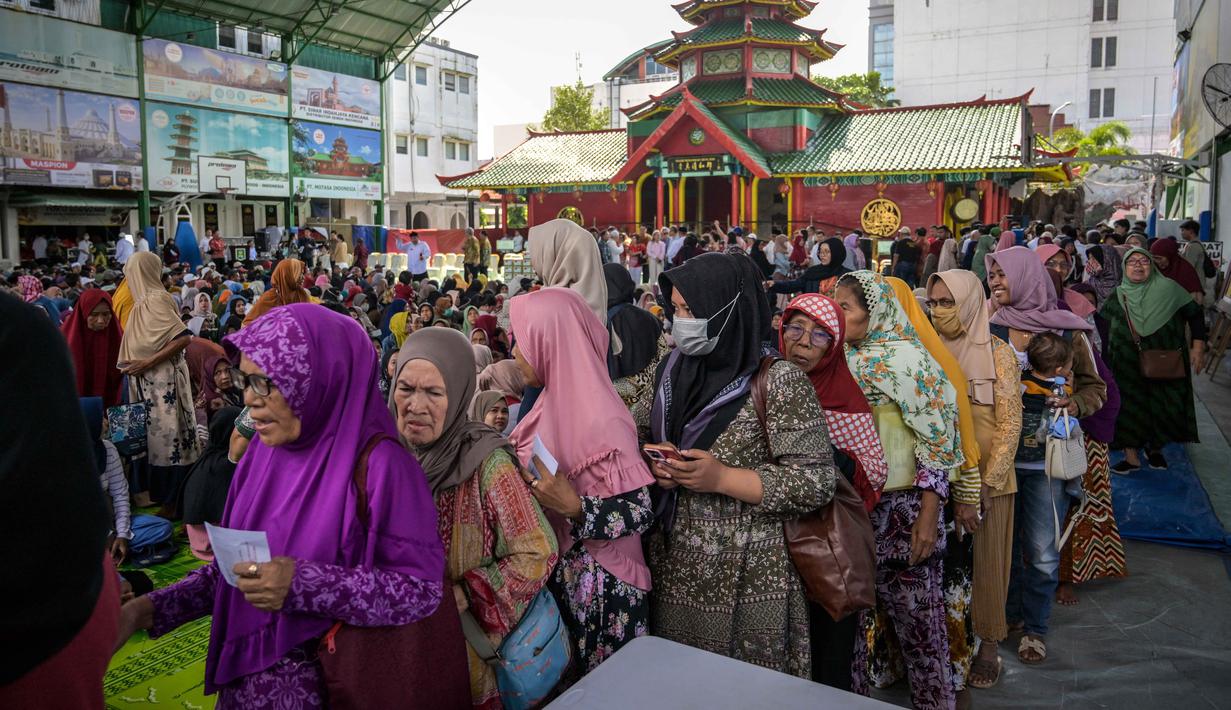 Untuk memastikan bantuan jatuh ke tangan yang tepat, pihak yayasan berkolaborasi dengan Pemerintah Kota (Pemkot) Surabaya. Tampak dalam foto, warga mengantre untuk menerima bantuan uang tunai di masjid Cheng Hoo, Surabaya, Jawa Timur pada Rabu 4 Maret 2026. (JUNI KRISWANTO/AFP)