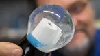 Pemilik perusahaan Original Vienna Snow Globes, Erwin Perzy III memegang bola salju yang berisi gulungan kertas toilet di Wina, Austria, pada 17 April 2020. Bola salju yang memiliki desain istimewa ini terinspirasi dari panic buying pada awal virus corona Covid-19. (ALEX HALADA/AFP)