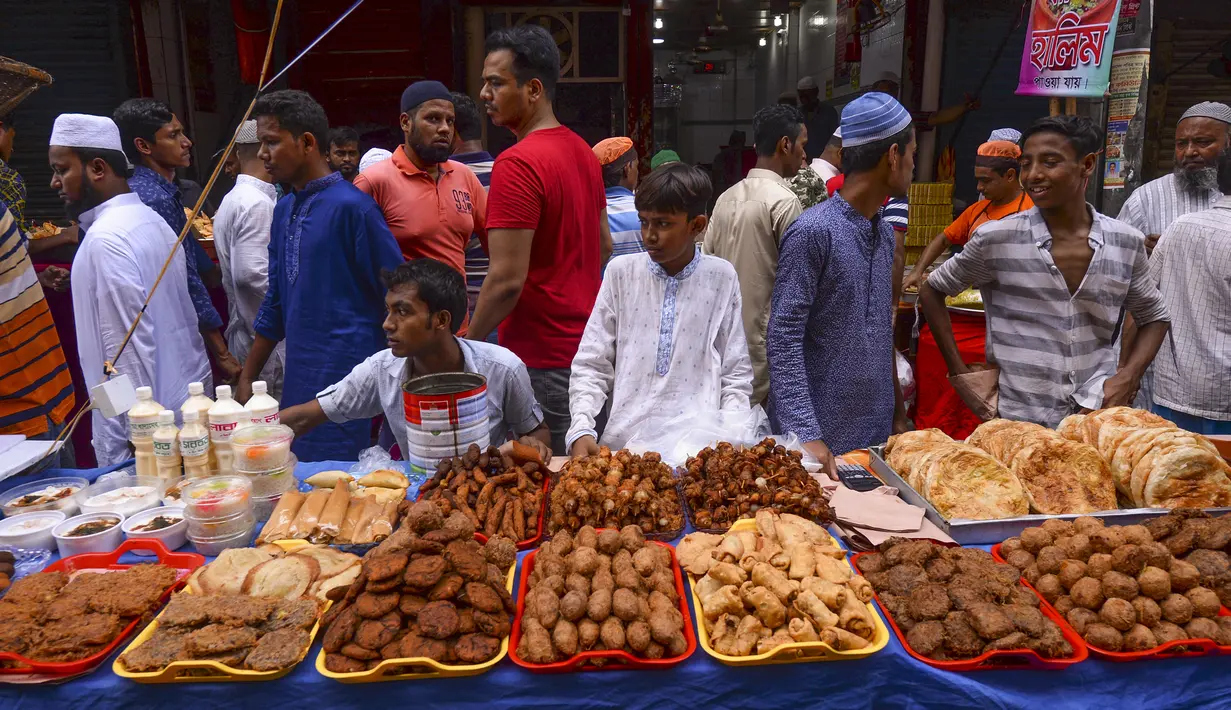 Pedagang kaki lima Bangladesh menjajakan makanan untuk berbuka puasa di pasar tradisional di Dhaka pada 10 Mei 2019. Seperti jutaan muslim di seluruh dunia, muslim Bangladesh berpuasa setiap hari selama bulan Ramadan dengan tidak makan dan minum dari subuh hingga petang. (MUNIR UZ ZAMAN/AFP)