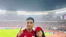 Maudy Effrosina memilih jersey Timnas warna putih, sementara Fadly Faisal tampil dengan jersey lengan panjang merah yang ia padukan dengan celana jeans. Kombinasi simpel namun tetap stylish ini menambah daya tarik keduanya di tengah euforia pertandingan. [@fadlyfsl].