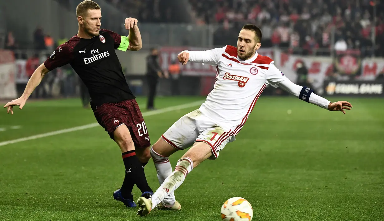 Pemain Olympiakos Piraeus, Kostas Fortounis berebut bola dengan pemain AC Milan, Ignazio Abate dalam laga keenam Grup F Liga Europa di Stadion Georgios Karaiskakis, Kamis (13/12). AC Milan tersingkir dari Liga Europa setelah kalah 1-3. (ARIS MESSINIS/AFP)