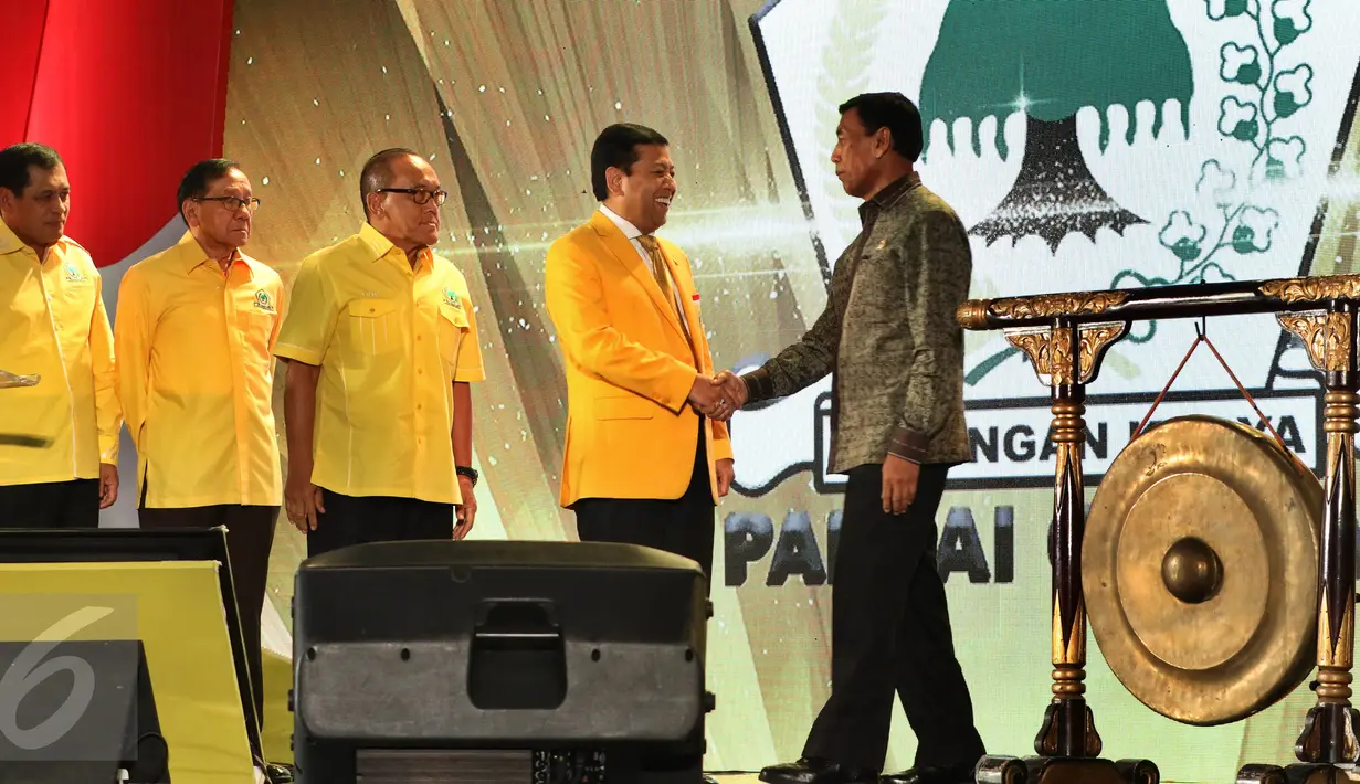 Menkopolhukam Wiranto berjabat tangan dengan Ketum Partai Golkar, Setya Novanto saat pembukaan Pertemuan Nasional - 1 Legislatif dan Eksekutif di Jakarta, Senin (26/9). Acara dihadiri kepala daerah dari kader  Golkar Se Indonesia. (Liputan6/JohanTallo)