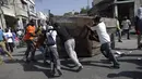 Pengunjuk rasa merusak tempat sampah saat demo pemilu di Port-au-Prince, Haiti (18/1). Warga menuduh pemilu presiden Haiti berjalan curang yang menyebabkan kemarahan warga hingga membakar fasilitas umum. (REUTERS/Andres Martinez Casares)