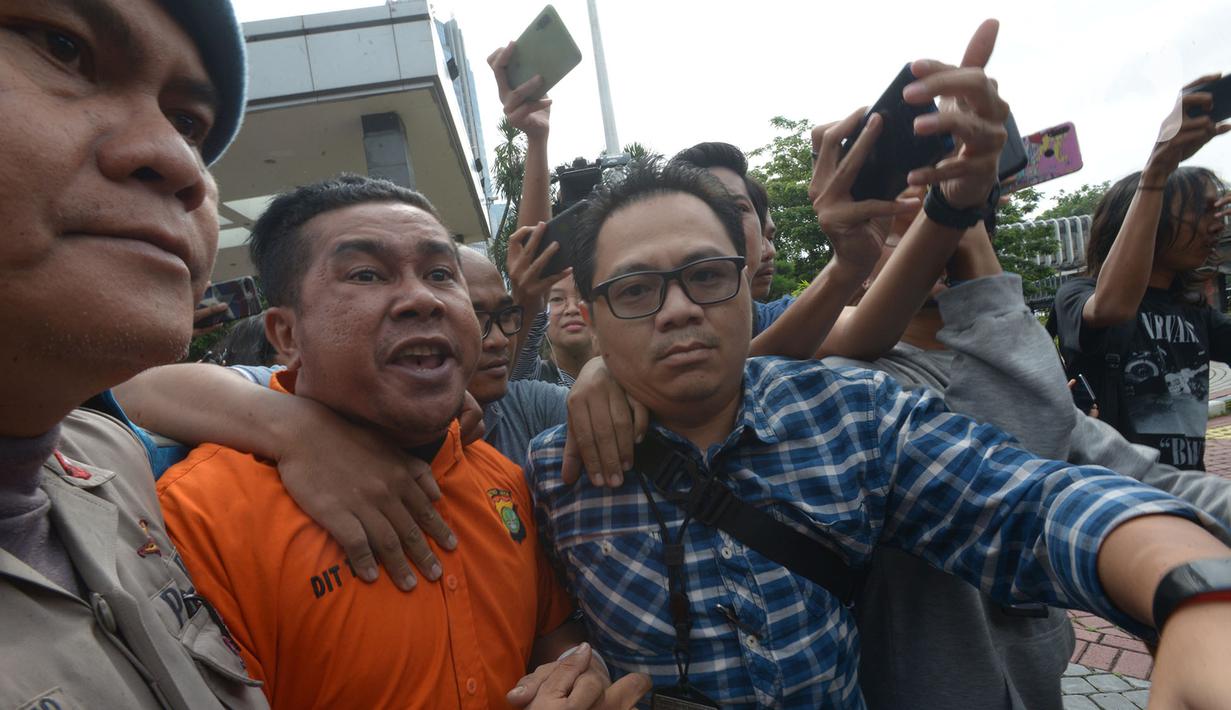 Polisi mengawal tersangka kasus penyiramanan air keras terhadap penyidik senior KPK Novel Baswedan di Polda Metro Jaya, Jakarta, Sabtu (28/12/2019). Tersangka berinisial RM dan RB dipindahkan dari Polda Metro Jaya ke Bareskrim Mabes Polri untuk penyidikan lebih lanjut. (merdeka.com/Imam Buhori)