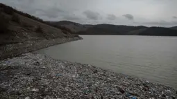 Kondisi ini diperparah oleh hujan deras dan genangan banjir yang membawa sampah dari pemukiman sekitar ke dalam waduk. Tampak dala foto, ceceran botol plastik dan sampah lainnya, yang hanyut terbawa hujan, mengapung di sepanjang Waduk Badovc di dekat Pristina, Kosovo pada Rabu 4 Februari 2026.