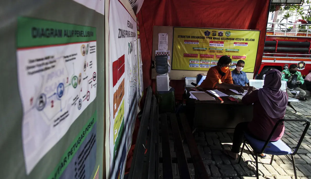 Petugas melayani warga penerima bantuan sosial (Bansos) di kawasan Kedoya Selatan, Jakarta Barat, Rabu (28/7/2021). Pemprov DKI Jakarta sebelumnya menganggarkan Rp 604 miliar untuk program BST bagi warga terdampak pandemi COVID-19. (Liputan6.com/Johan Tallo)