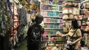 Pekerja melayani calon pembeli pernak-pernik Natal di salah satu toko di Pasar Asemka, Jakarta, Kamis (9/12/2021). Meski masih berada di masa pandemi Covid-19, penjualan pernak-pernik Natal di Pasar Asemka mengalami peningkatan. (merdeka.com/Iqbal S Nugroho)