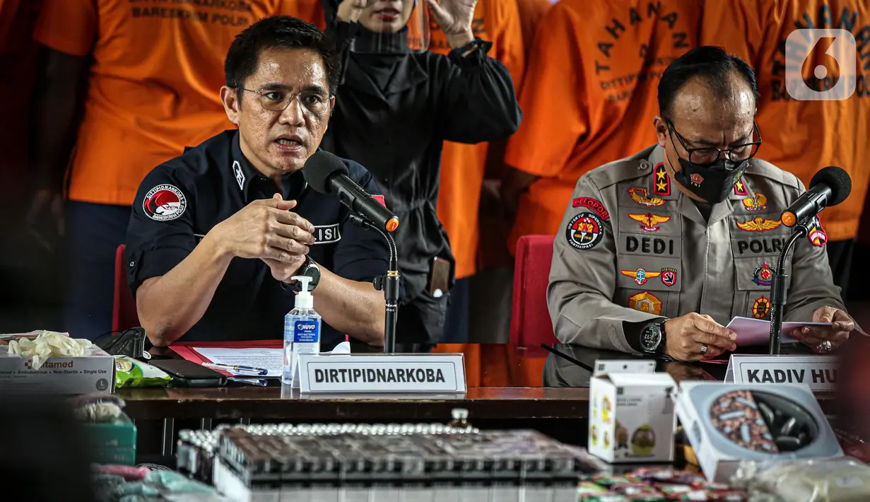 Direktur Tindak Pidana Narkoba Bareskrim Polri Brigjen Krisno Halomoan Siregar (kiri) menyampaikan keterangan saat rilis kasus narkoba jaringan internasional di Gedung Bareskrim Mabes Polri, Jakarta, Kamis (11/8/2022). Direktur Tindak Pidana Narkoba Bareskrim Polri Brigjen Krisno Halomoan Siregar mengatakan, peredaran narkoba kembali gencar karena kelonggaran PPKM disalahgunakan oleh sejumlah tempat hiburan malam. (Liputan6.com/Faizal Fanani)