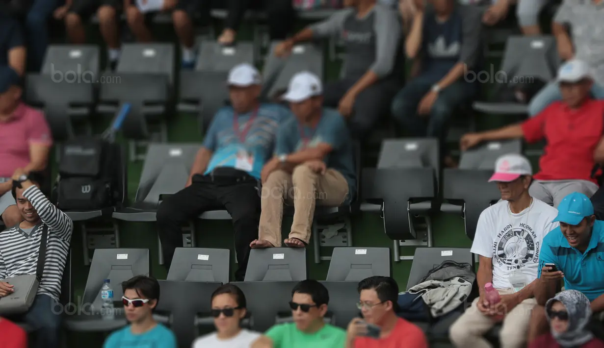 Diharapkan penyelenggara aktif mengingatkan penonton untuk tidak mengangkat kaki pada sandaran kursi di lapangan Tenis di Senayan, Jakarta, Sabtu (4/2/2018). Renovasi Lapangan Tenis ini memakan biaya sekitar 92 miliar rupiah.  (Bola.com/Nick Hanoatubun)