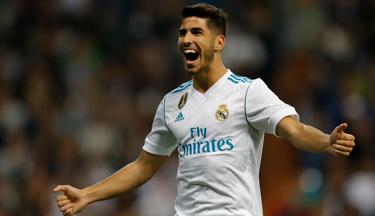 Pemain Real Madrid, Marco Asensio berselebrasi setelah mencetak gol ke gawang Eibar dalam lanjutan La Liga pekan kesembilan di Stadion Santiago Bernabeu, Minggu (22/10). Madrid menang tiga gol tanpa balas. (AP/Francisco Seco)