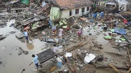 Warga mengumpulkan perkakas dari bangunan rumahnya yang rusak akibat terjangan tsunami di Kampung Sumur Pesisir, Pandeglang, Banten, Senin (24/12). Pascatsunami Selat Sunda, warga pulang untuk mencari  barang berharga miliknya. (Merdeka.com/Arie Basuki)