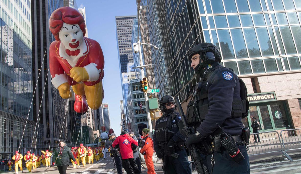 Polisi berjaga saat Balon Ronald McDonald memeriahkan parade Hari Thanksgiving di Manhattan, New York, AS (23/11). Peringatan 'Thanksgiving' merupakan Hari Pengucapan Syukur di akhir musim panen. (AP Photo/Mary Altaffer)